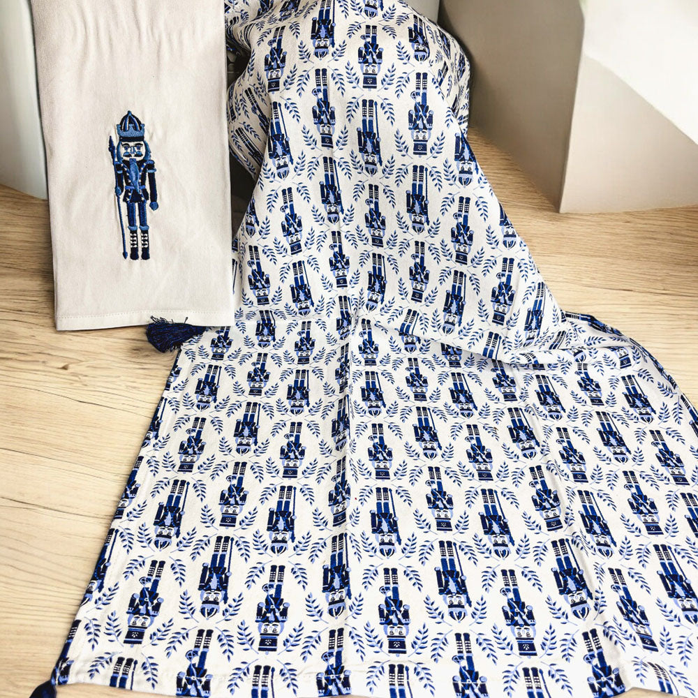 Nutcracker-themed tea towel with off-white base, blue nutcracker applique, blue tassels