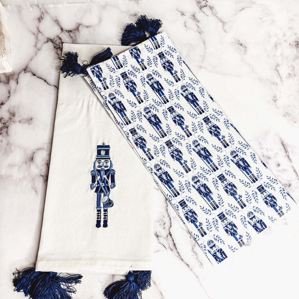 Nutcracker tea towel with off-white panel, blue nutcracker applique, and tassel accents