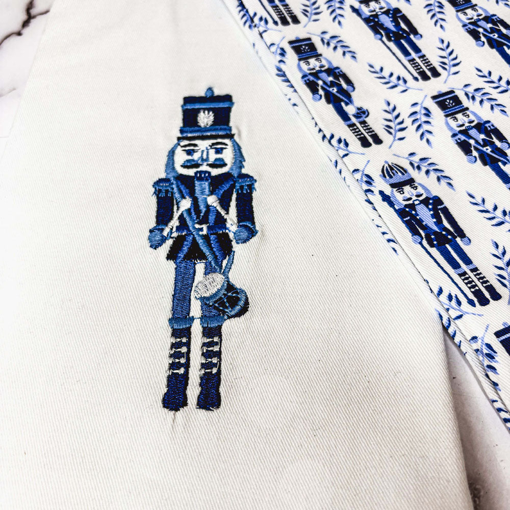 Close-up of nutcracker applique on off-white nutcracker tea towel with blue trim