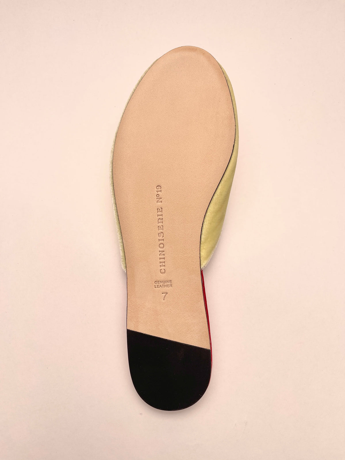 Underside of lemon velvet mule slipper with black outsole and pale insole