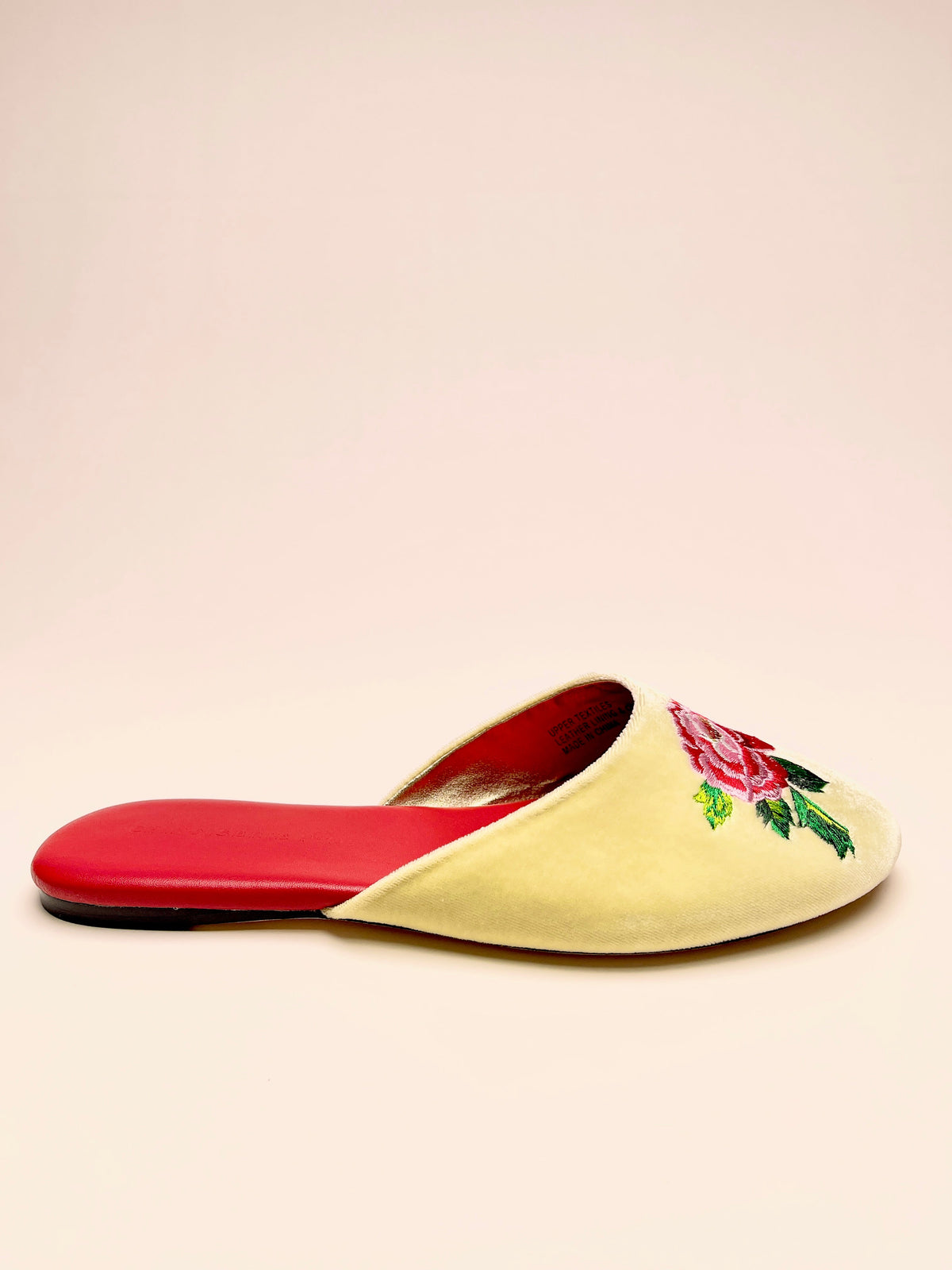 Lemon velvet mule slipper with peony floral embroidery and red sole trim, side view
