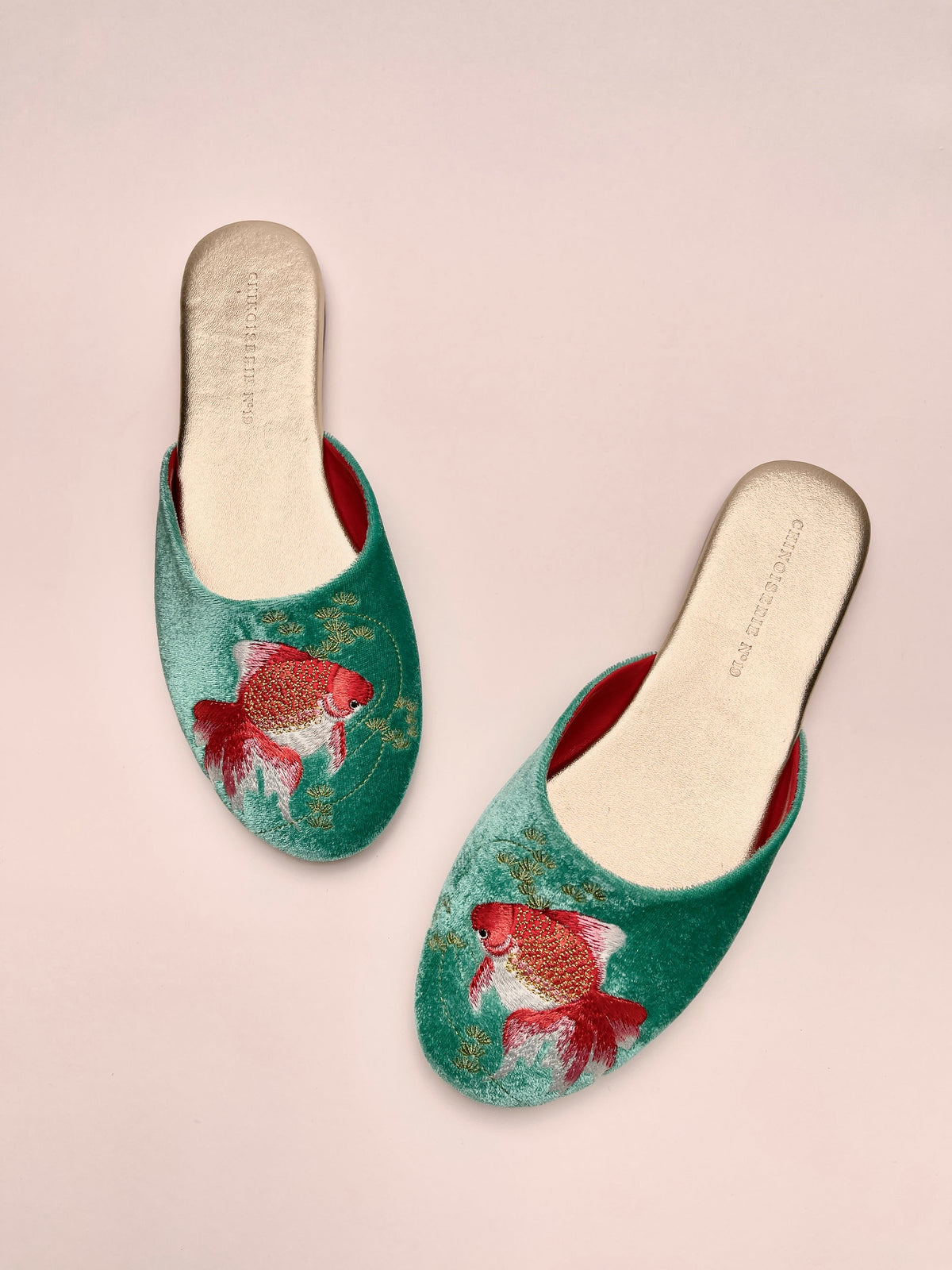 Jade velvet mules showing goldfish embroidery on slip-on uppers