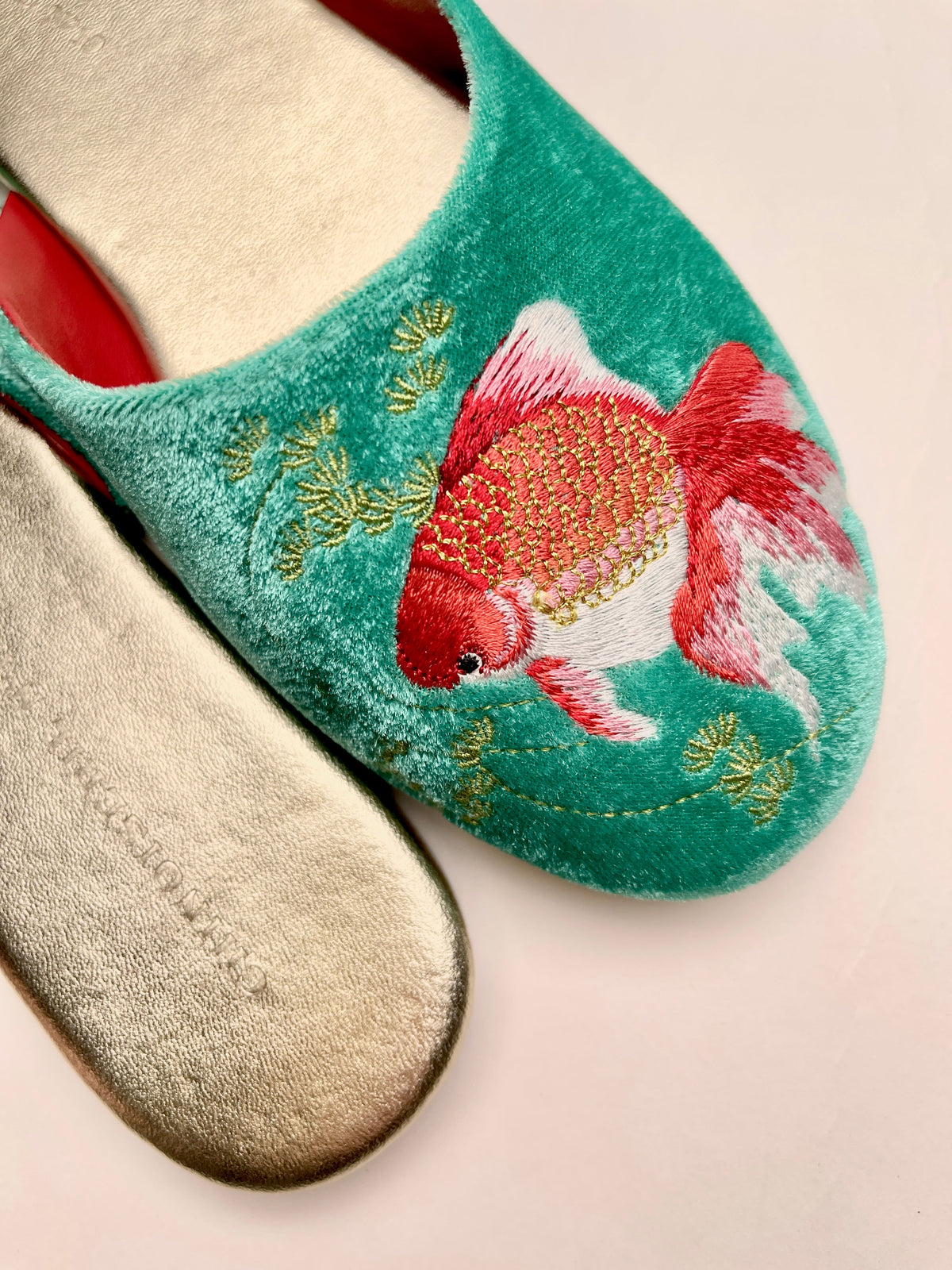 Close-up of jade velvet mule with goldfish embroidery on the vamp