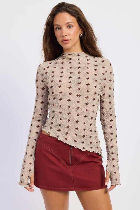 Light beige star-print knit top with long sleeves and curved hem