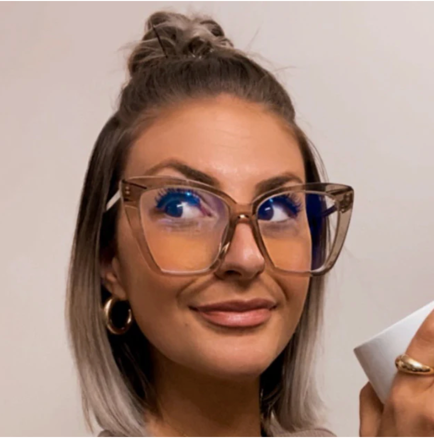 Amber tortoise square glasses with clear lenses and broad frames, worn close-up