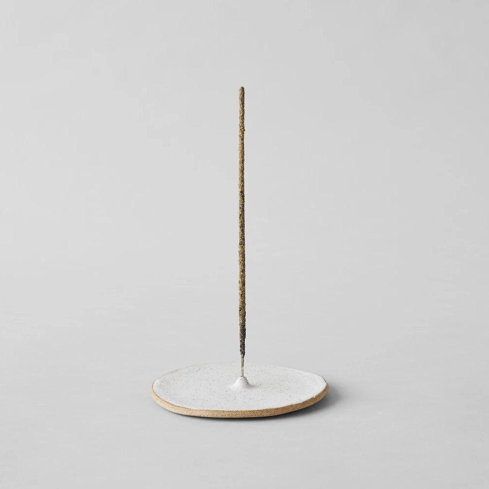 Speckled incense holder with round base and upright incense stick
