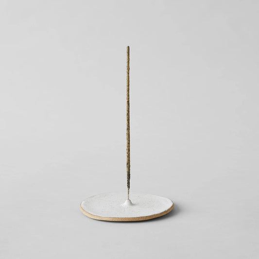 Speckled incense holder with round base and upright incense stick