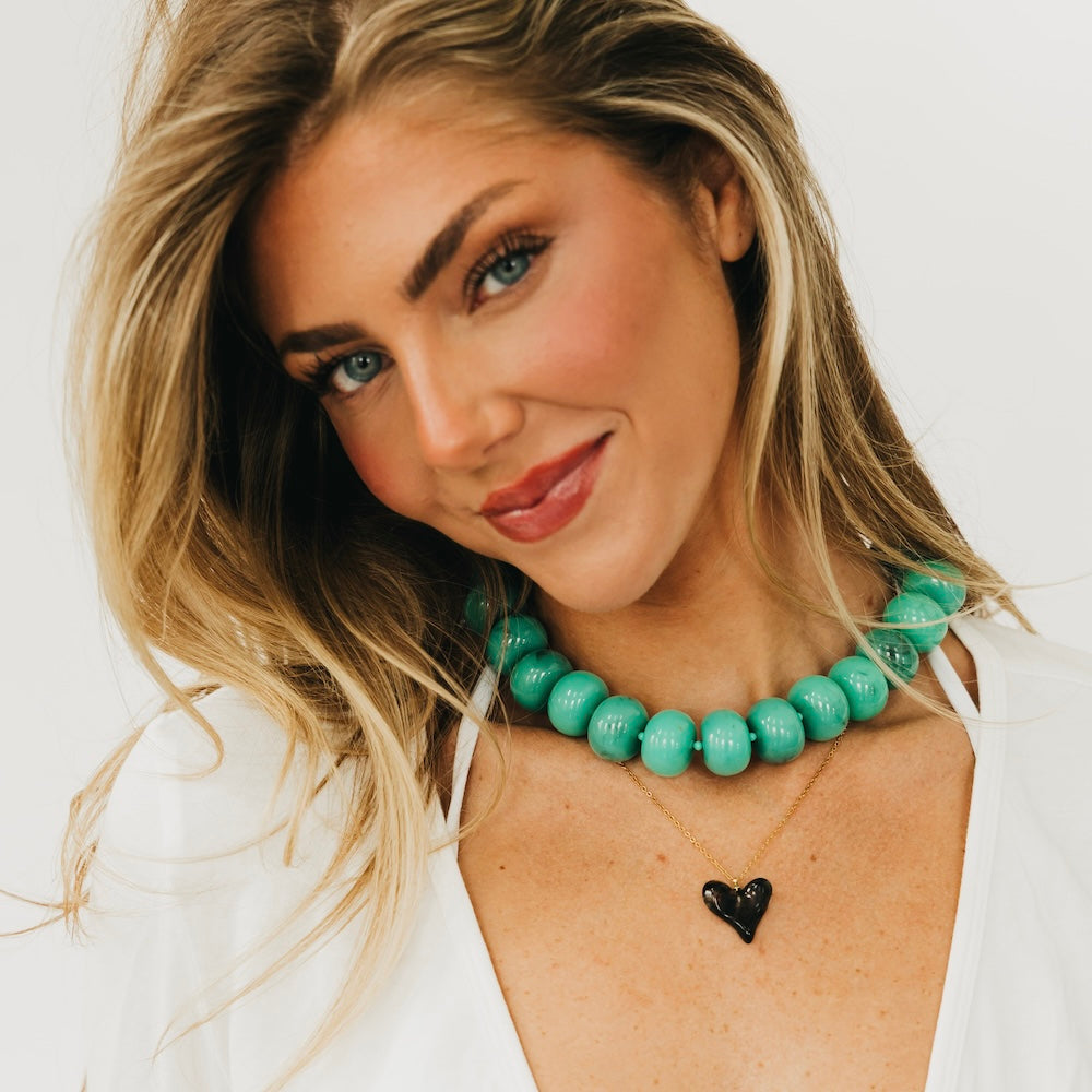 Black resin heart pendant necklace on a thin gold chain