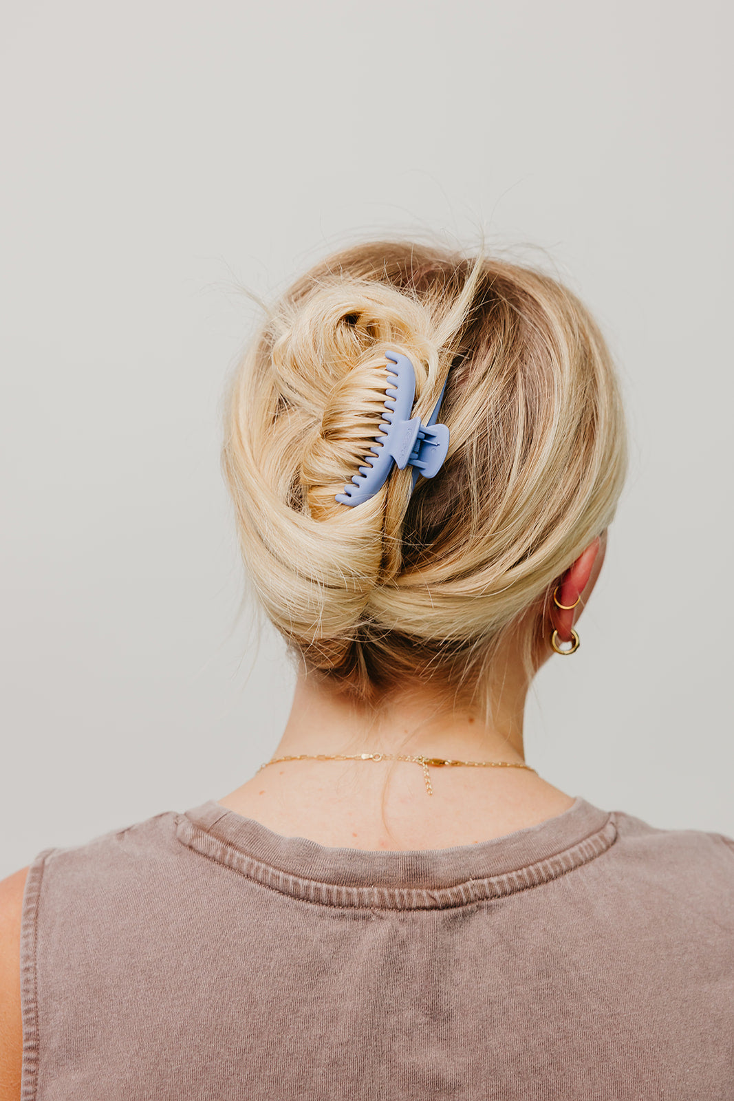 Matte mini hold-everything claw hair clip, blue, in blonde hair bun