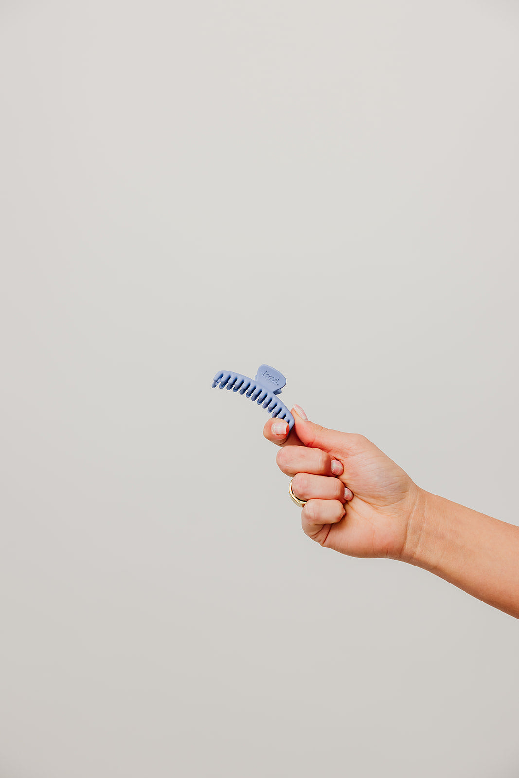 Matte mini claw hair clip, blue, held in hand