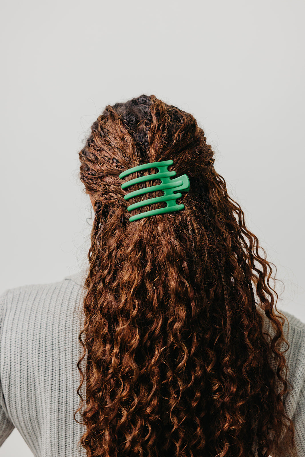 Wide hair claw clip in teal green on long curly brown hair