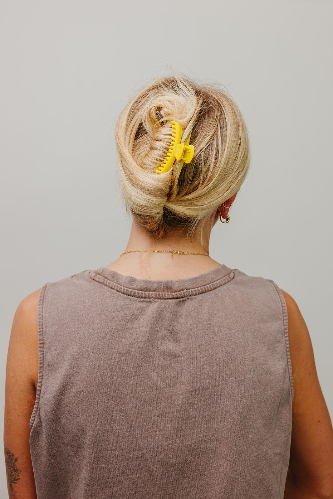 Matte mini hold-everything claw hair clip, yellow, securing blonde hair on back of head