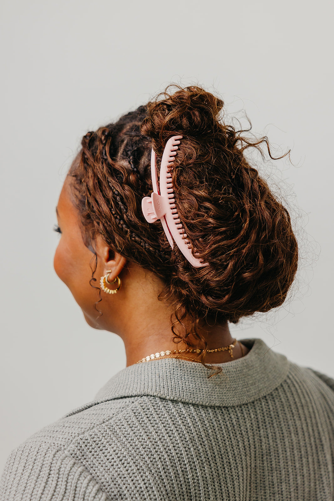 Cream matte claw hair clip in dark curly hair, side view