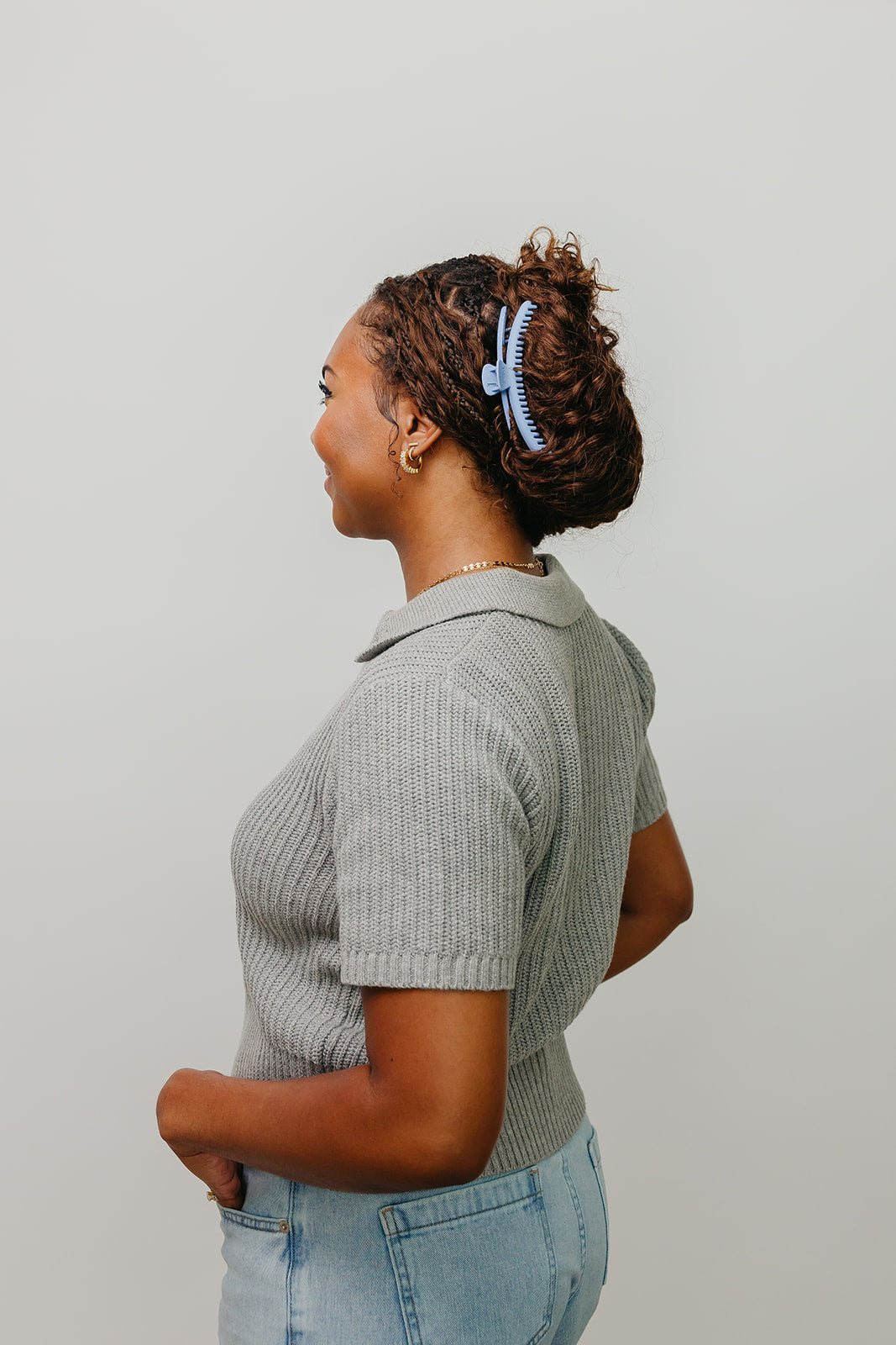 Light blue matte claw hair clip on curly hair, shown from the side
