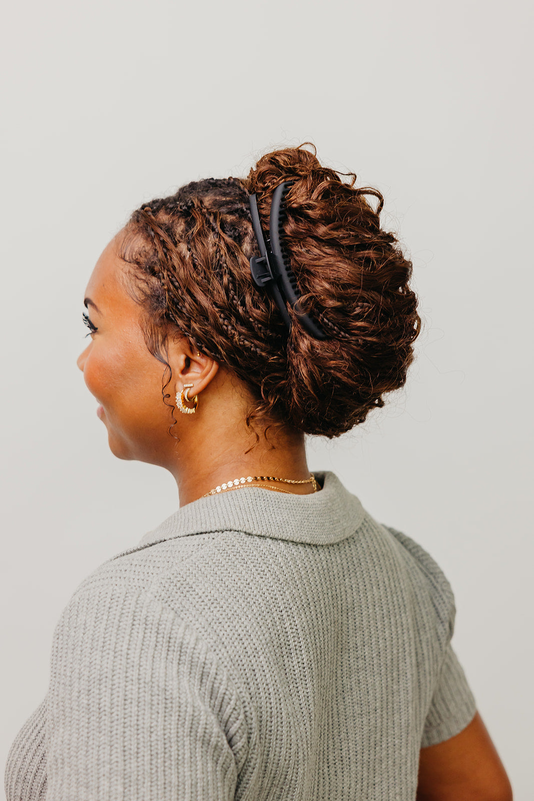 Black matte claw hair clip in hair, side view on brown curly hair