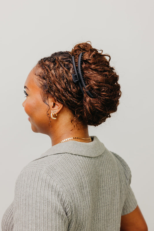 Black matte claw hair clip in hair, side view on brown curly hair