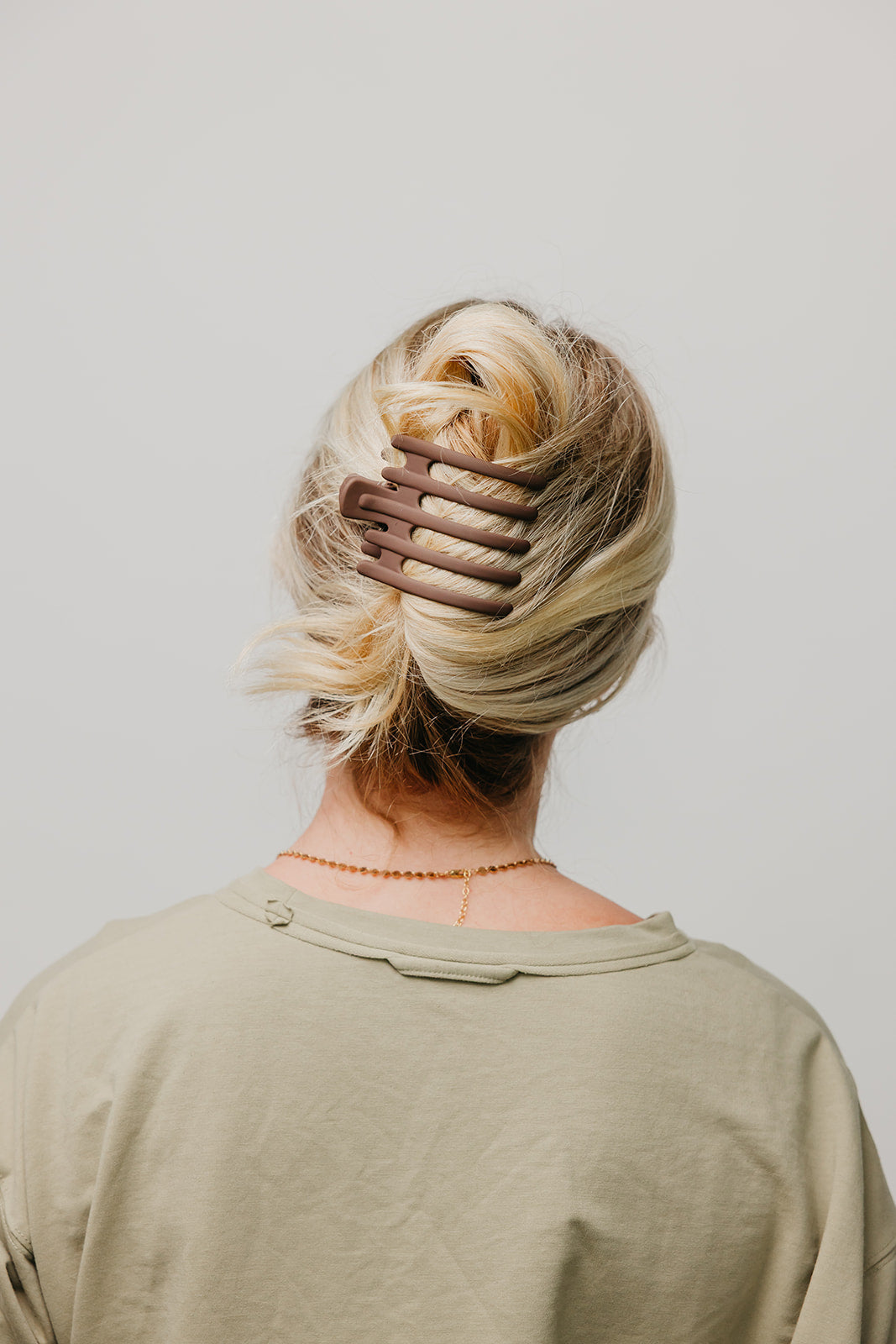 Hair claw clip in matte dark brown on blonde hair from the back