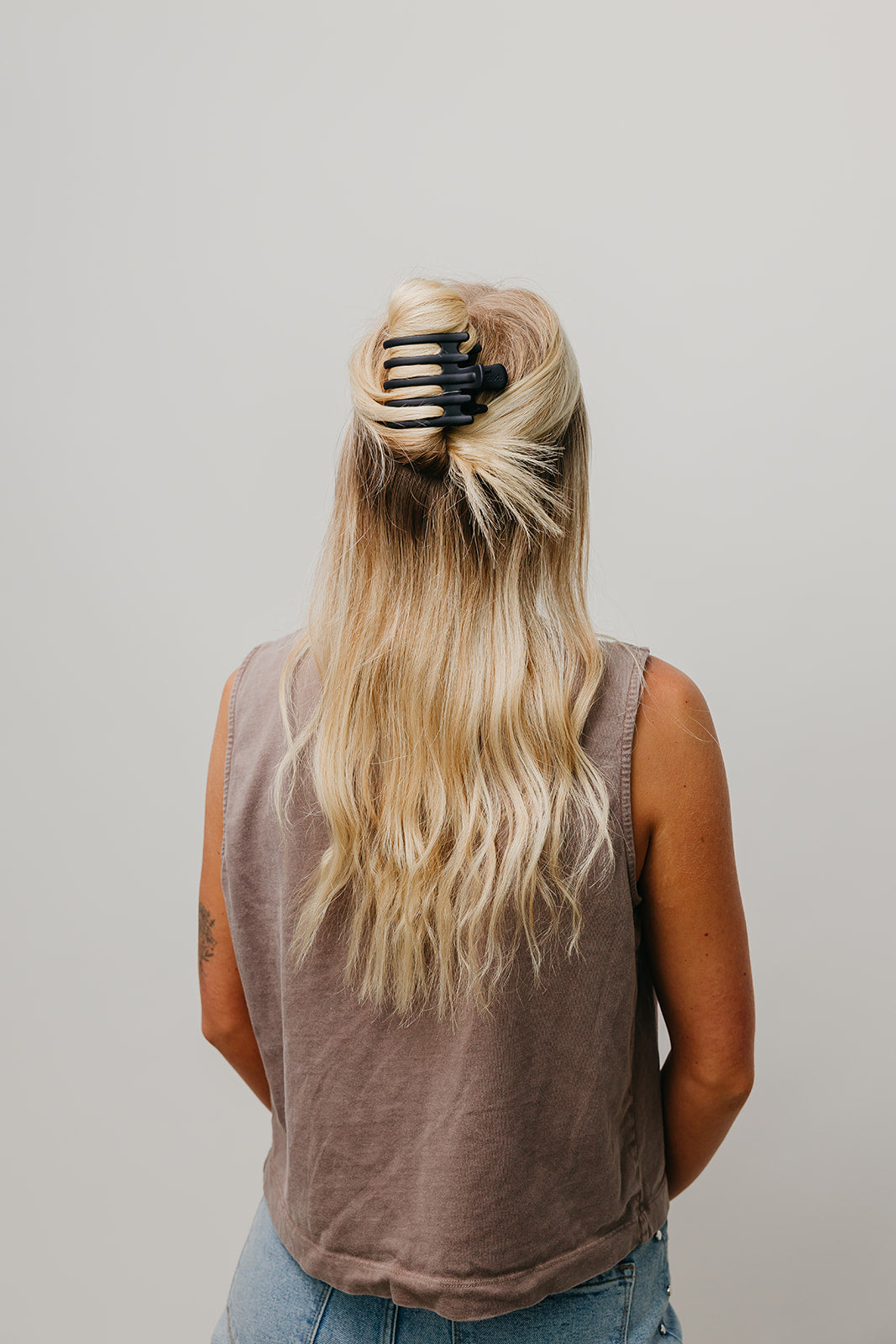 Hair claw clip in dark brown holding blonde hair up