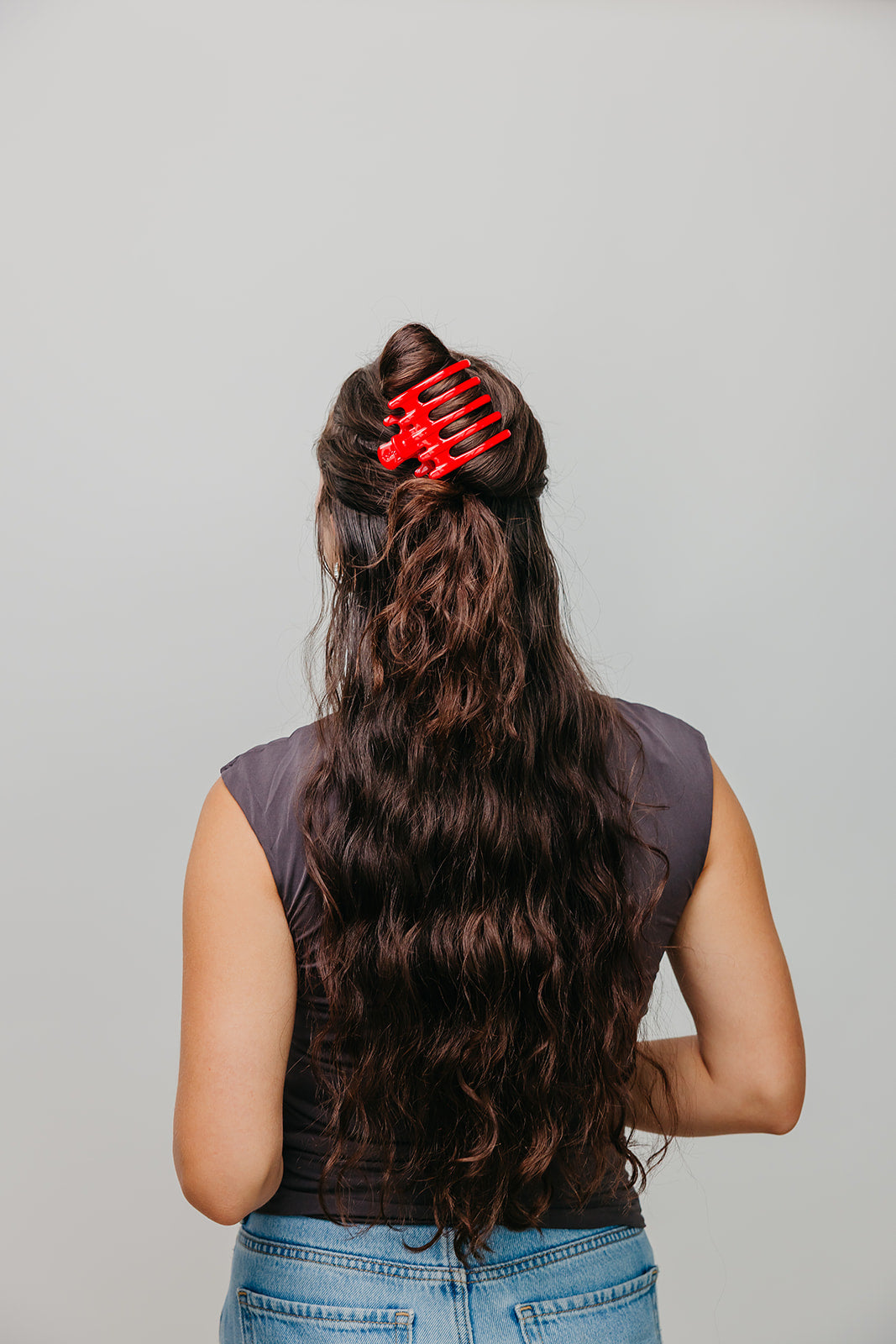 Wide red hair claw clipped in long dark hair, back view