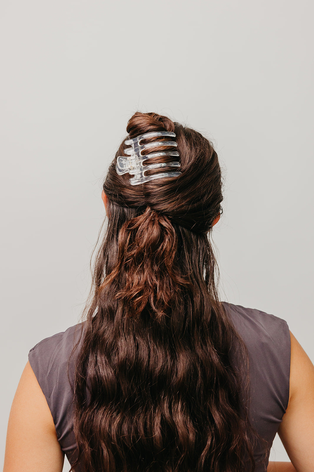 Clear wide hair claw clip clipped on dark brown hair