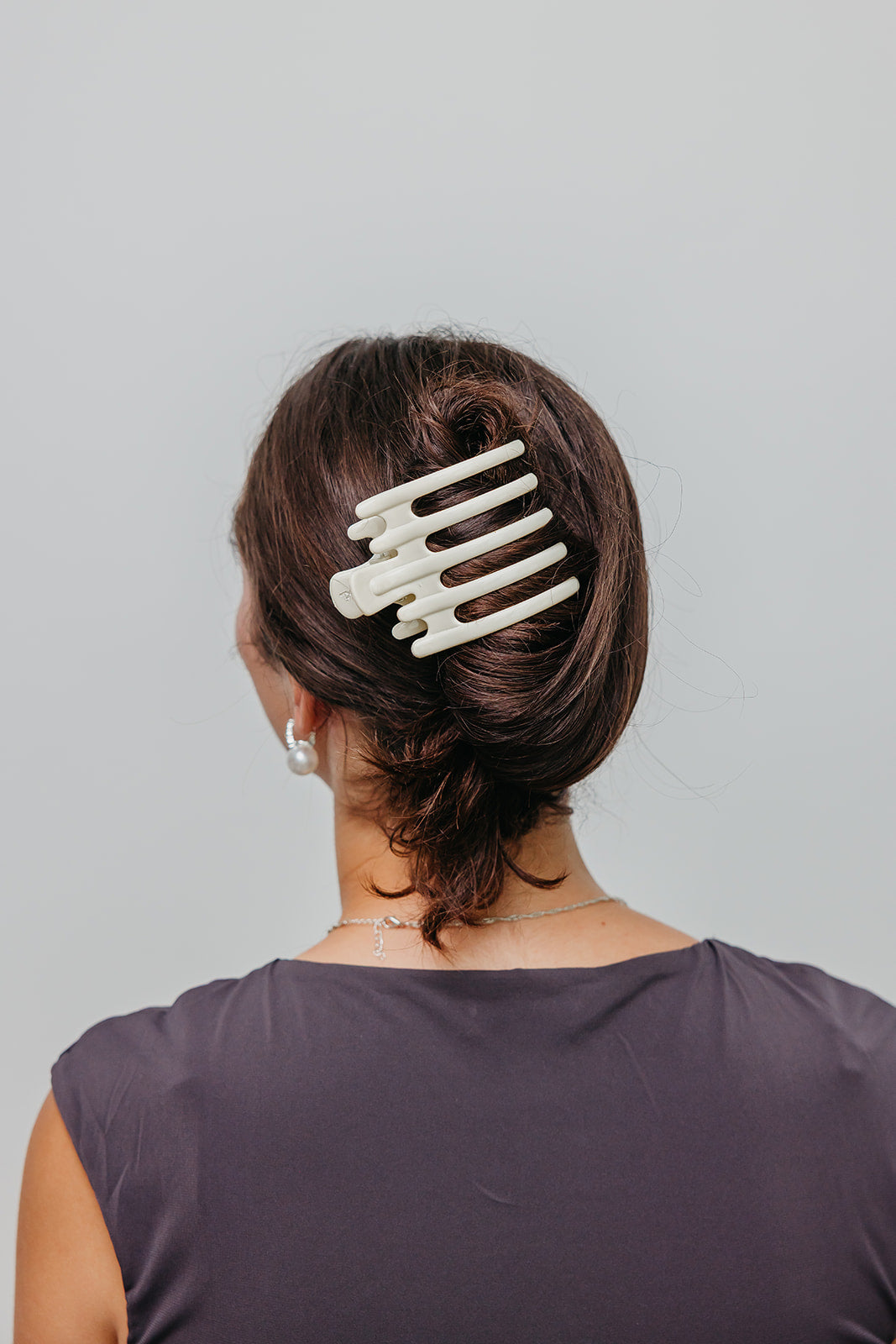 Wide laydown claw hair clip, white/ivory finish on dark hair