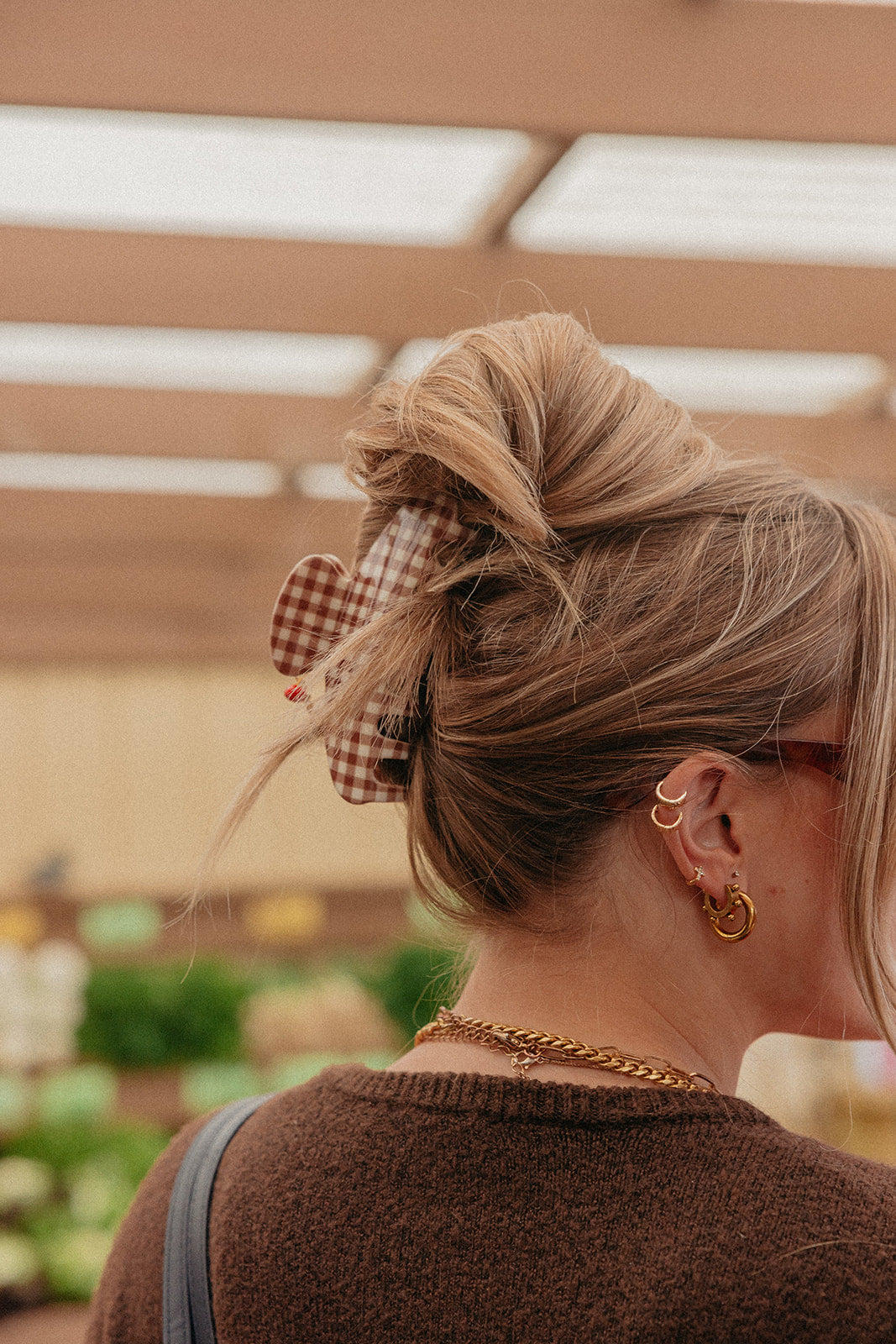 Brown gingham hair claw securing blonde bun at the nape