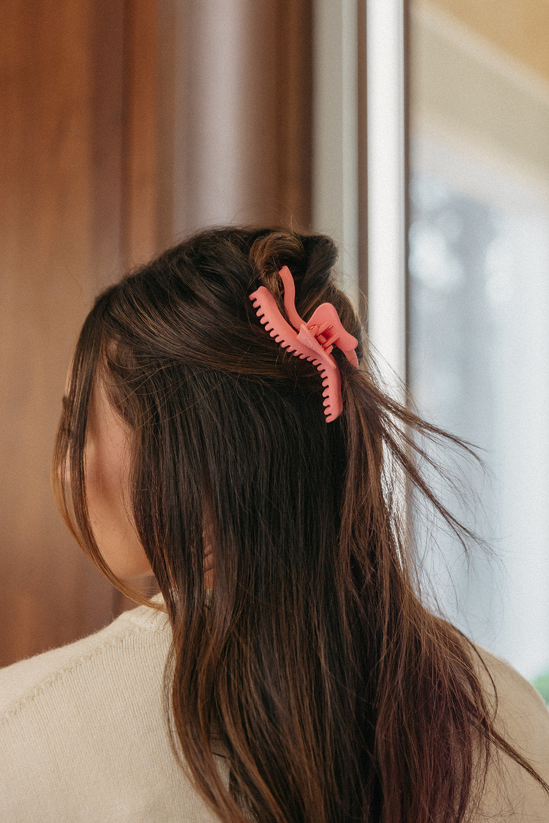 Pink wavy hair claw clip securing long dark hair