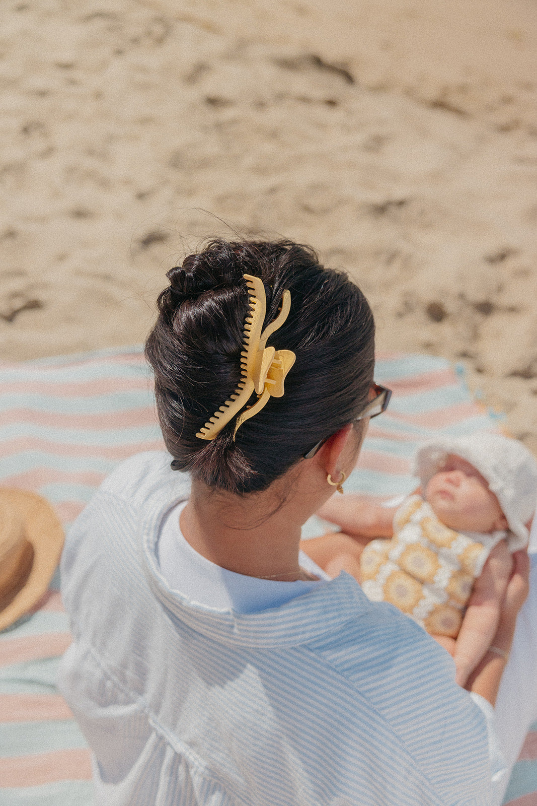 Yellow-gold wavy hair claw clip holding a low bun