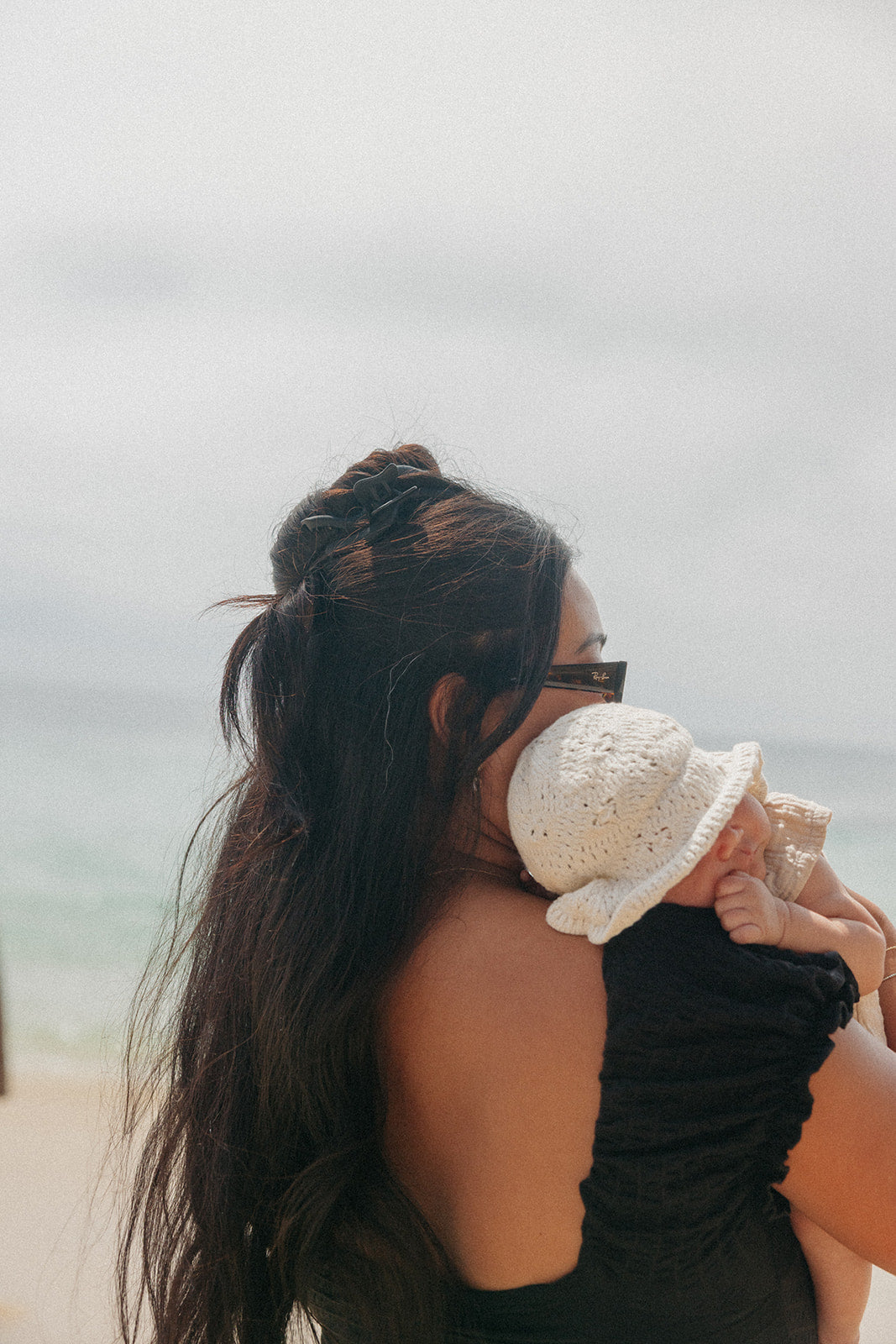 Wavy hair claw clipped in long dark hair bun, close side view