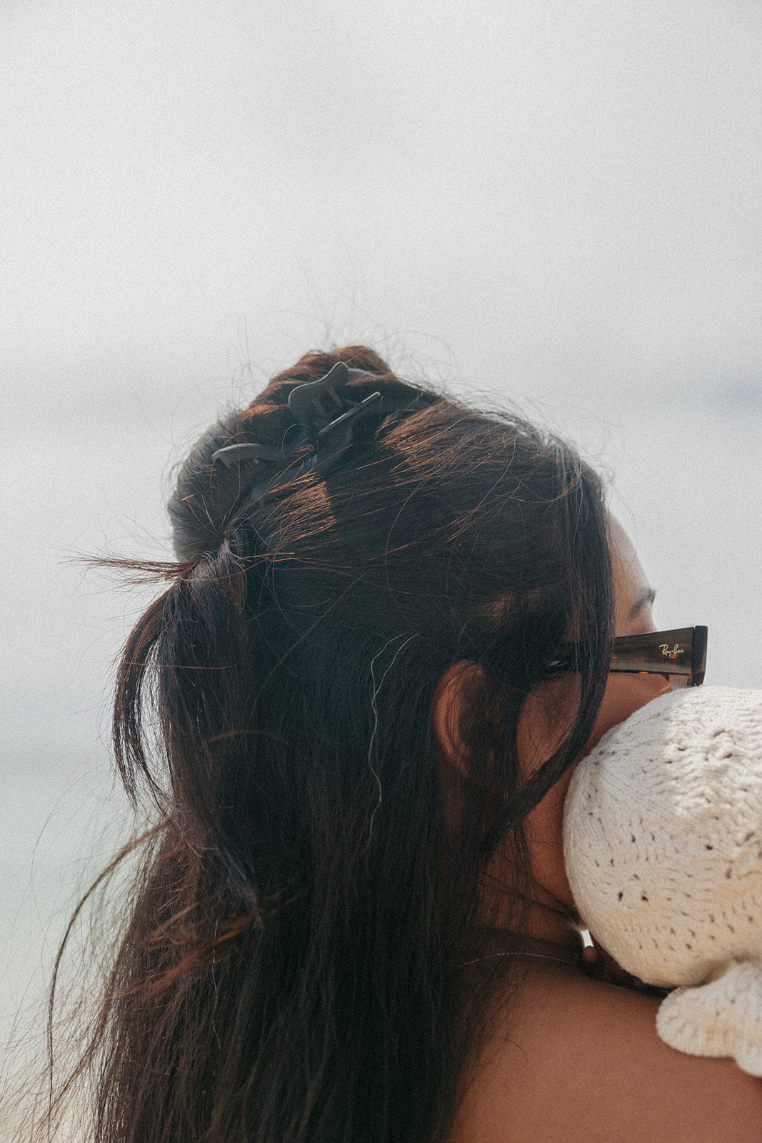 Wavy hair claw clipped on dark brown hair bun, side close-up