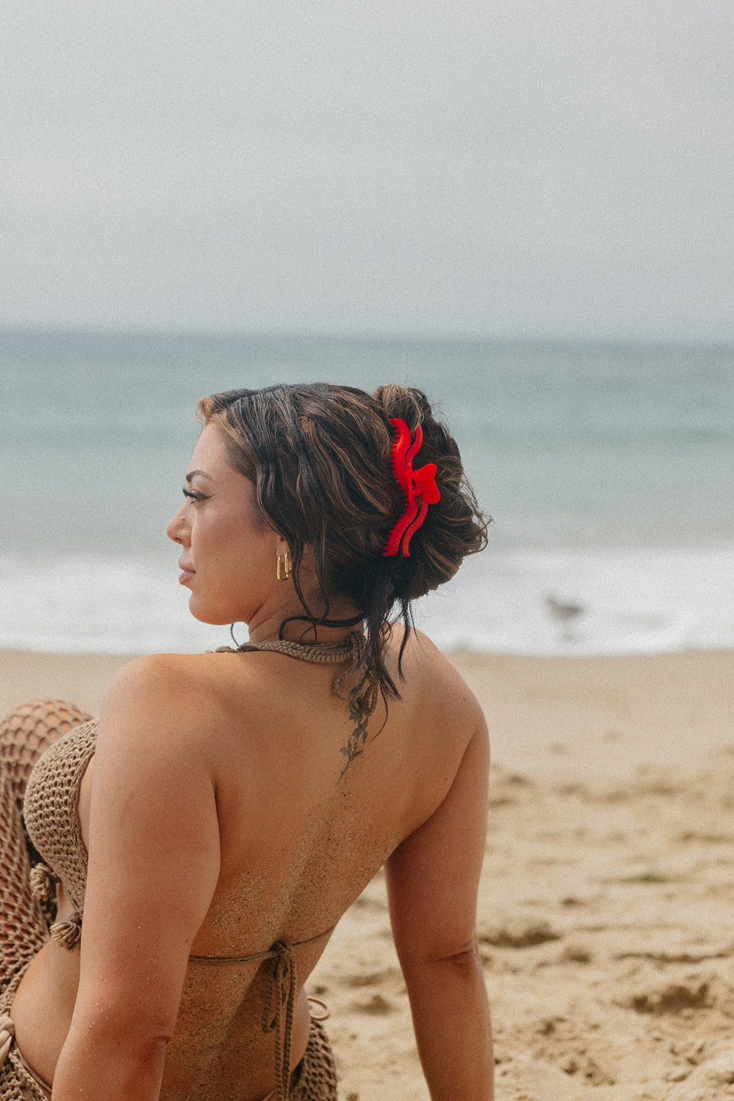 Red wavy hair claw holding back hair on a woman