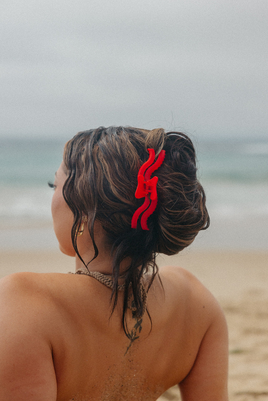 Red wavy hair claw clipped into dark hair bun