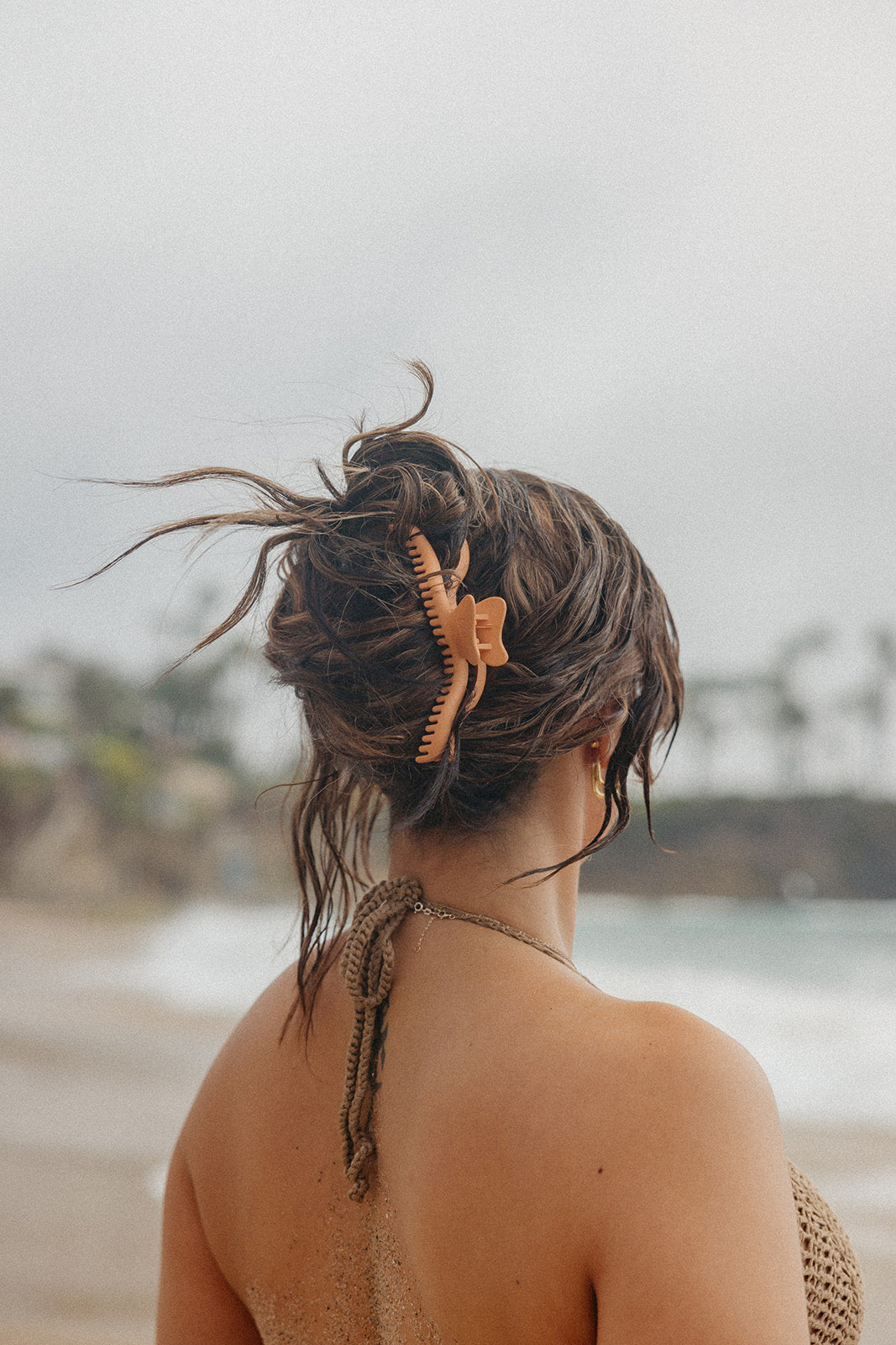 Orange hair claw clip with wavy center and comb teeth holding hair back.