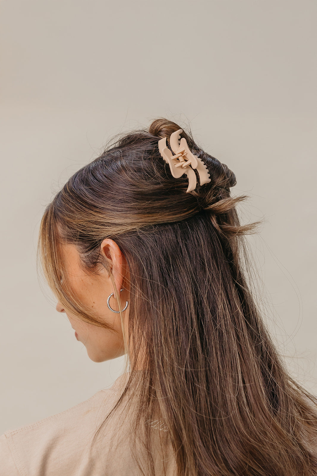 Beige wavy mini hair claw holding brown hair up
