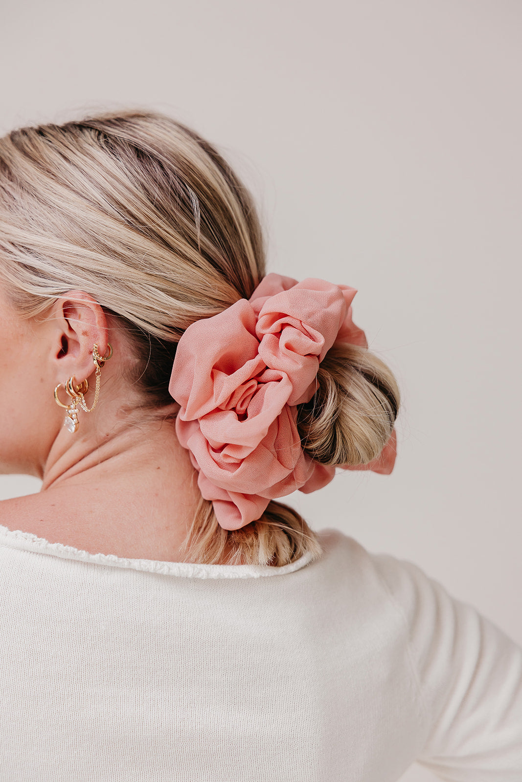 Jumbo scrunchie in coral pink ruffle flower style on blonde ponytail