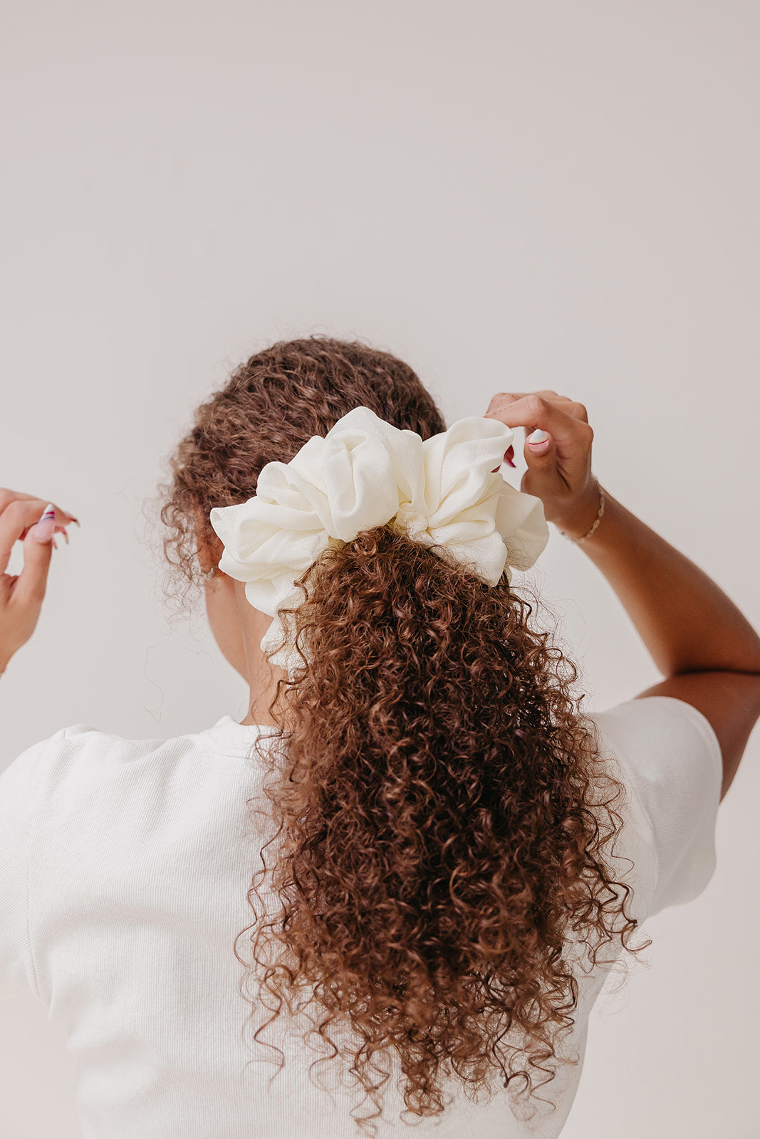 Ivory jumbo scrunchie worn in a curly hair updo