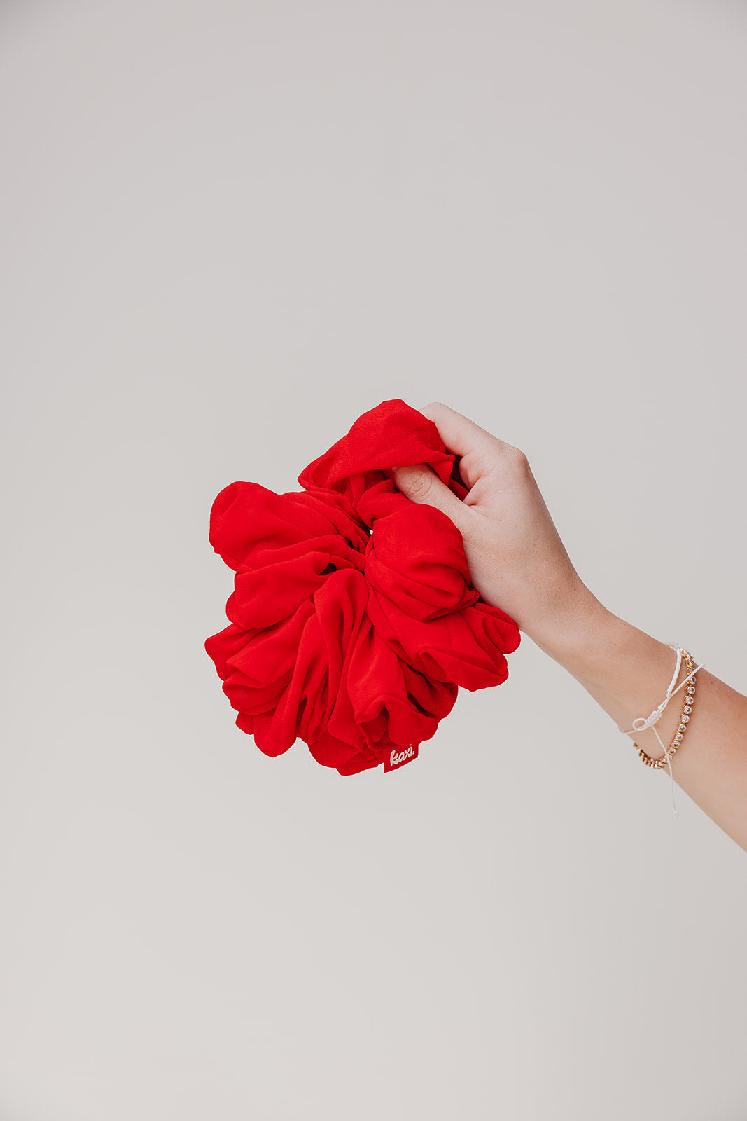 Jumbo scrunchie, vivid red ruffled scrunchie in hand