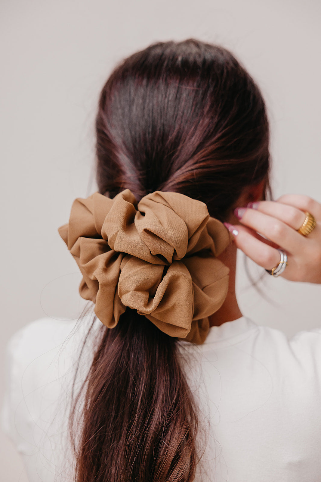 Brown jumbo scrunchie on hair with thick gathered folds