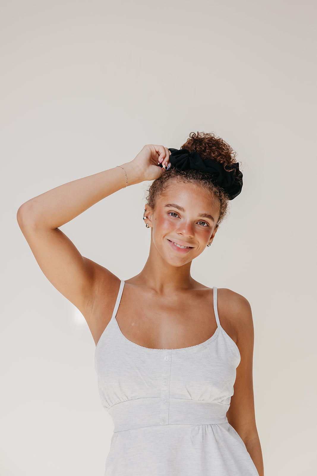 Black jumbo scrunchie in styled hair updo on a smiling child