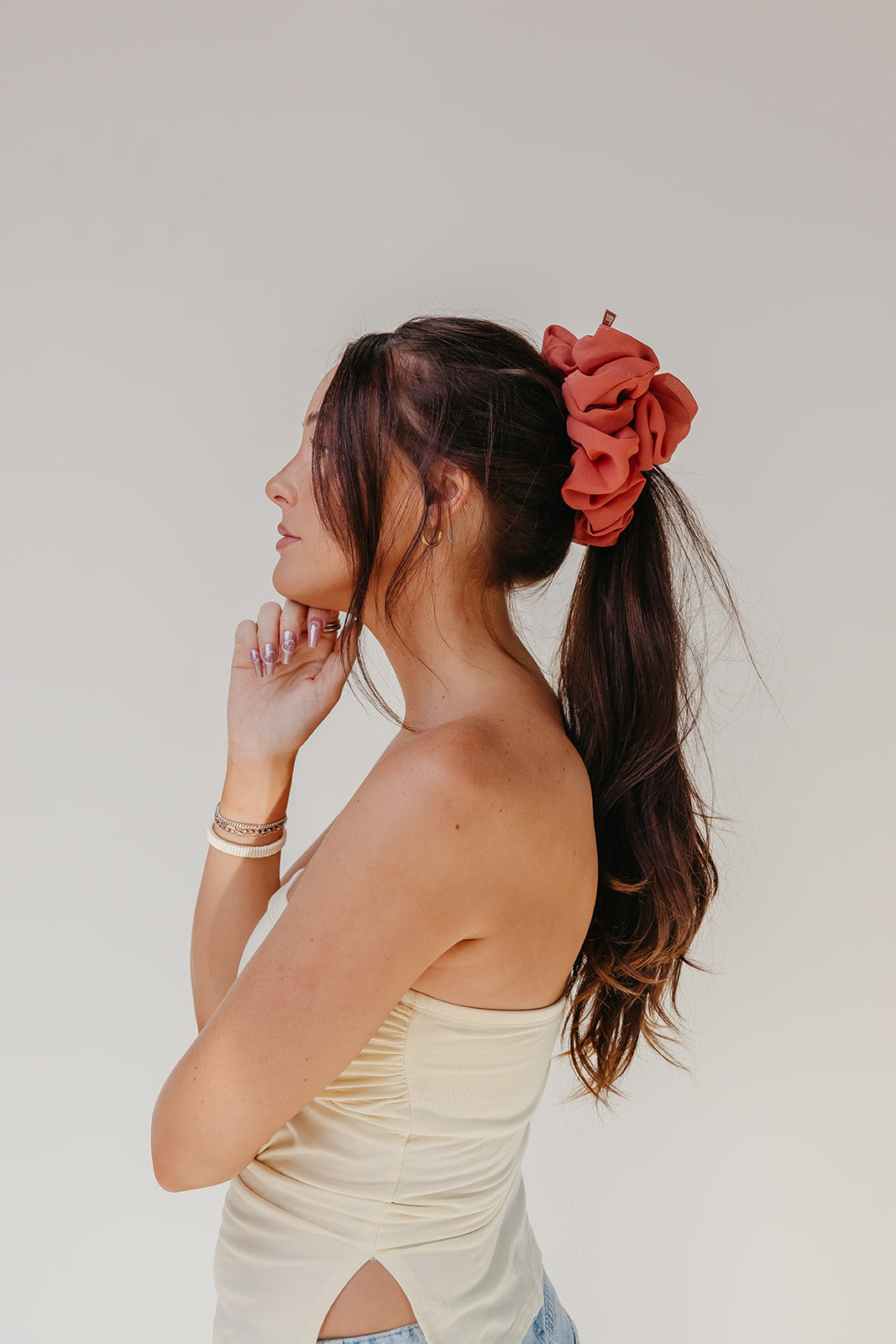 Jumbo scrunchie in red-orange ruffled flower on dark ponytail