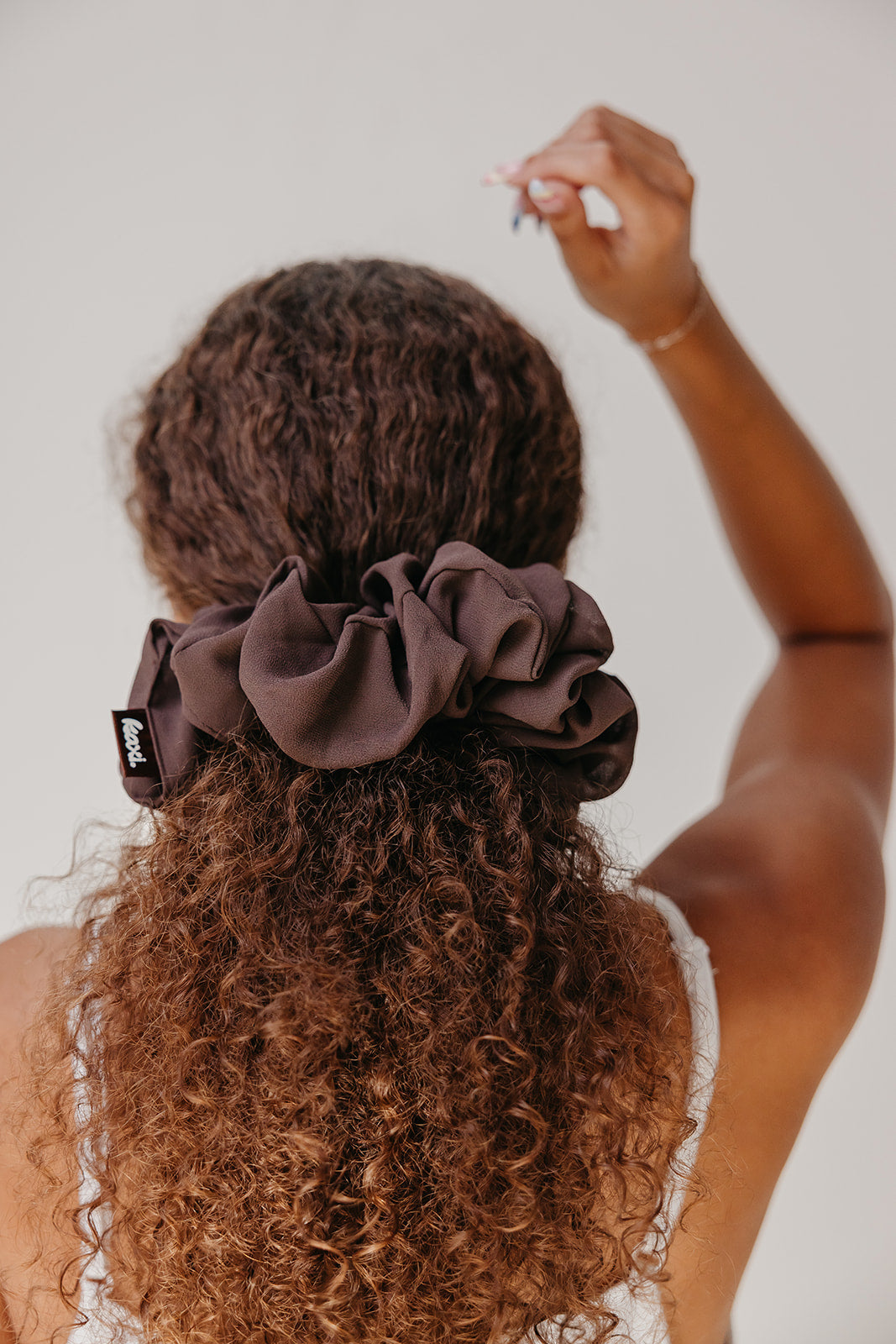 Dark brown jumbo scrunchie on curly hair, large gathered folds