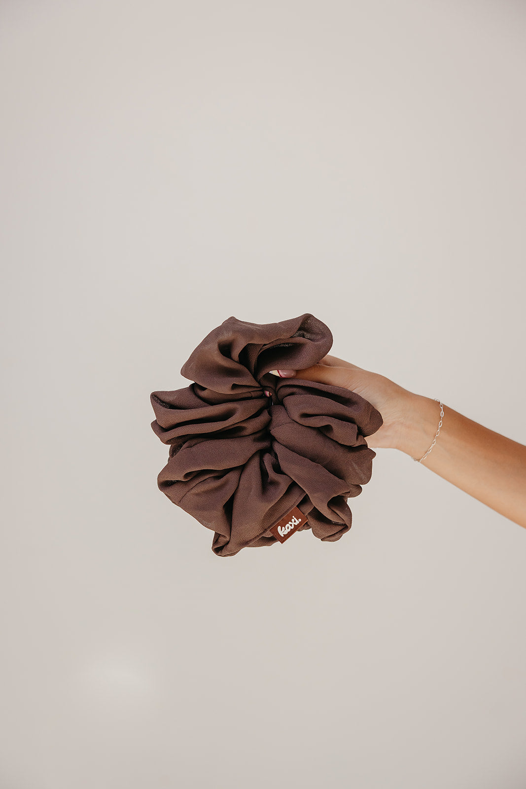 Jumbo scrunchie in dark brown fabric, scrunched ruffle style.