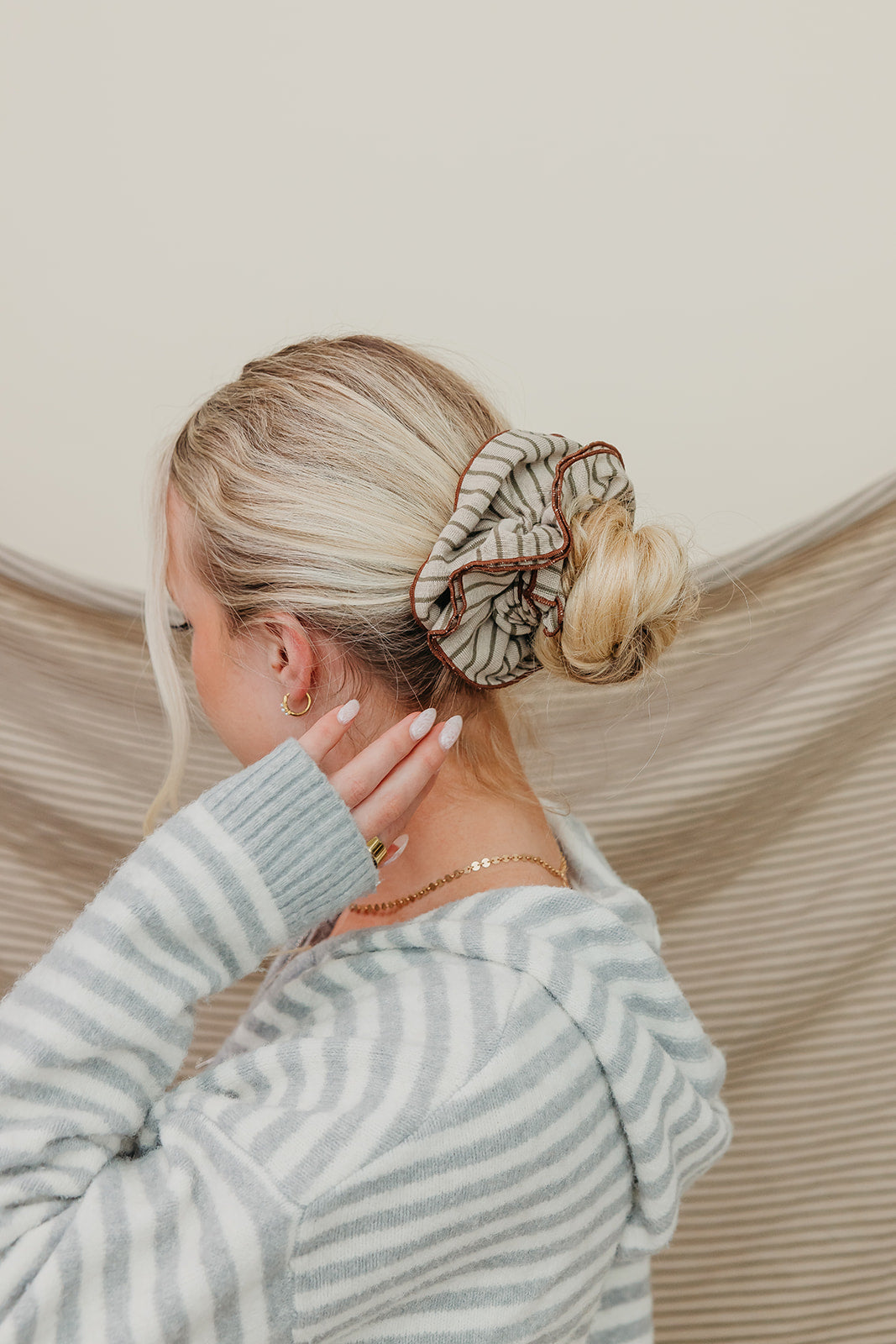 Tan and brown striped corset-style scrunchie worn in low blonde bun