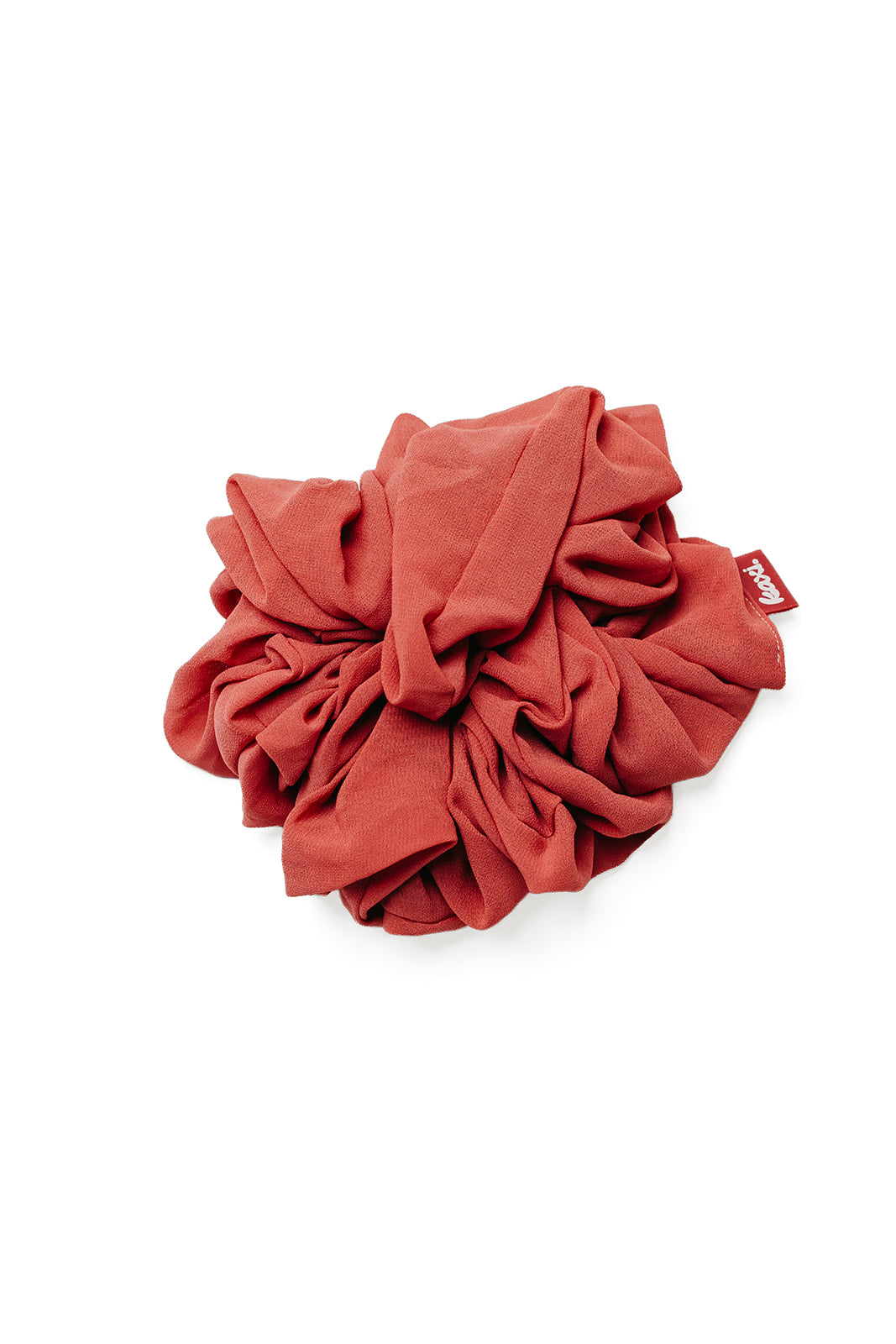 Jumbo scrunchie close-up in red-orange gathered ruffle with small tag