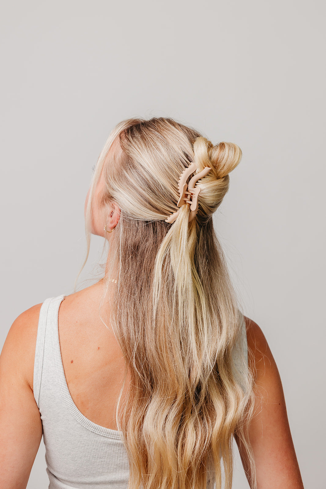 Wavy hair claw holding blonde hair half-up, rear view