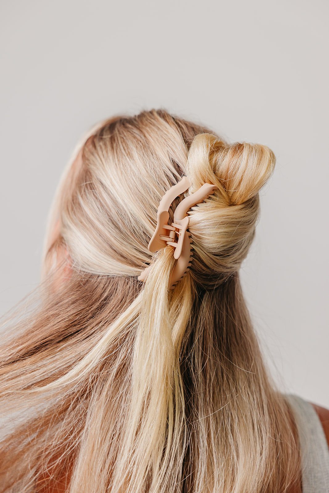 Wavy hair claw clipped on blonde hair, spiral bun detail