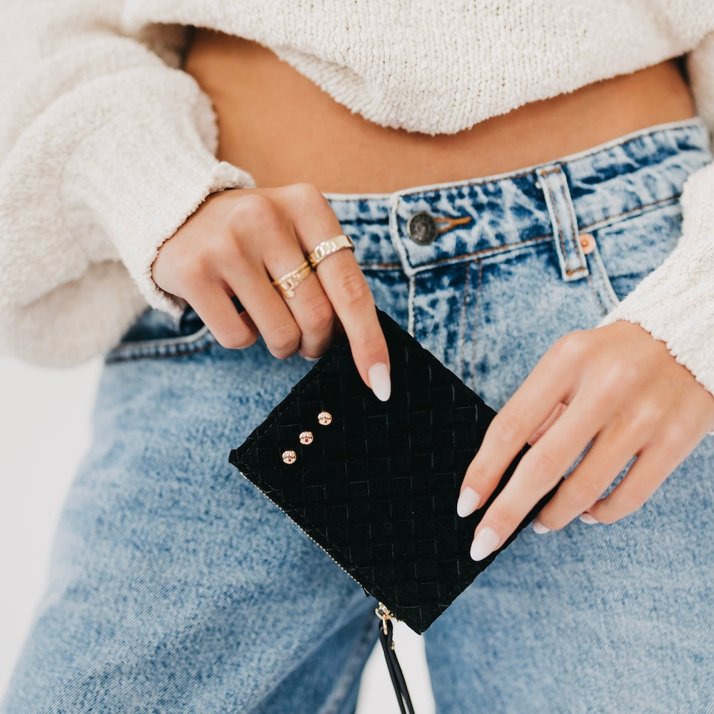 Woven suede wallet in black with snap studs and a gold zipper pull.