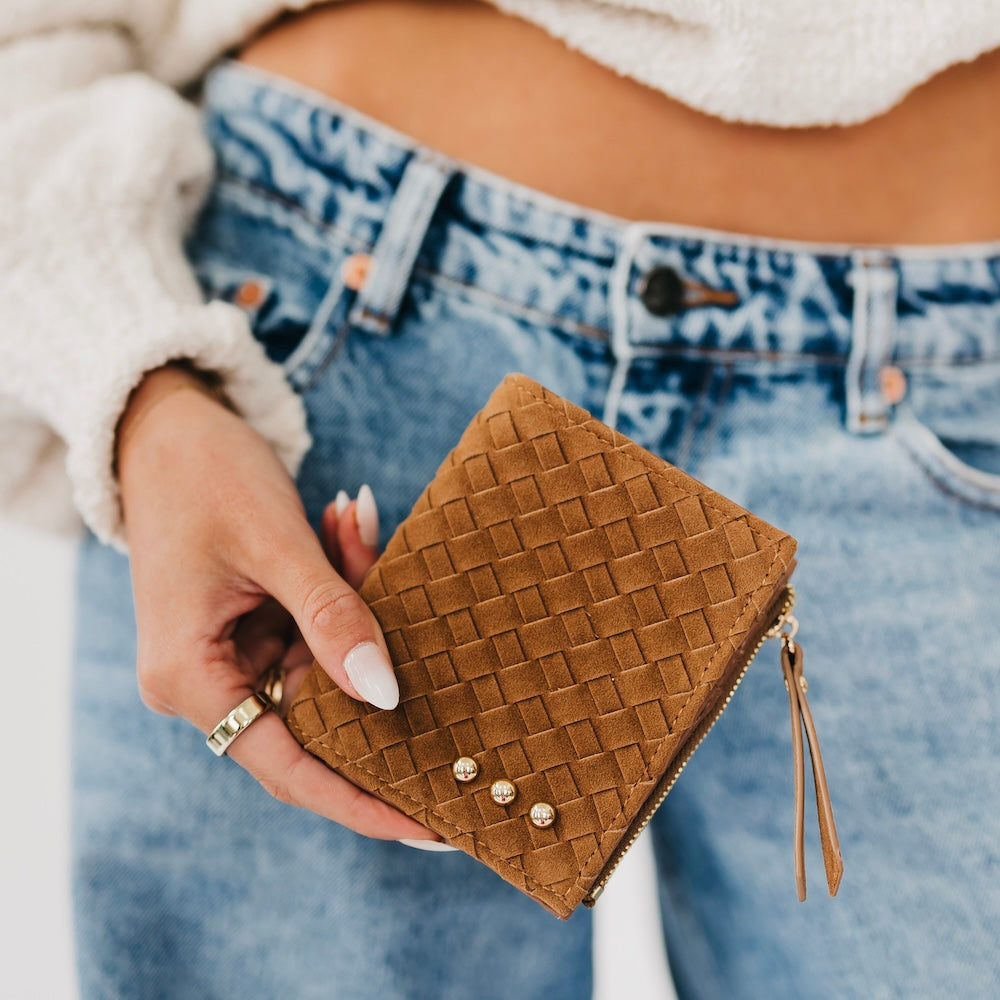 Woven suede wallet in brown with snap studs and gold tassel zipper pull.