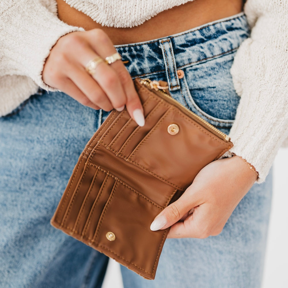 Woven suede wallet in tan with snap studs and gold zipper pull.