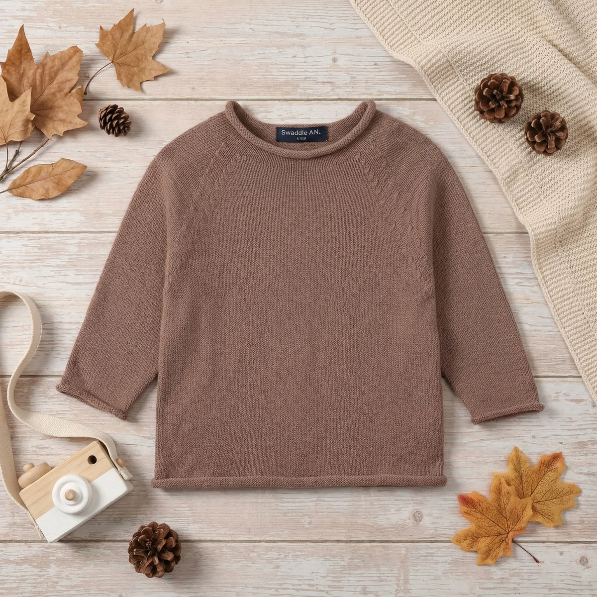 Mocha knit rollneck baby sweater with ribbed neckline and long sleeves